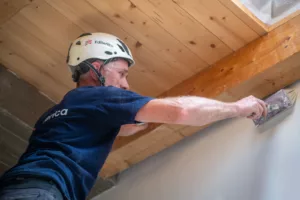 Operaio Edilerica al lavoro su un solaio in legno